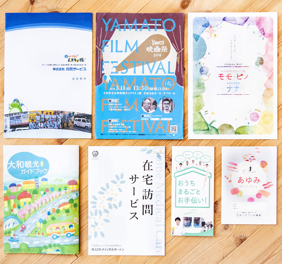 制作実績のパンフレットを机に並べている