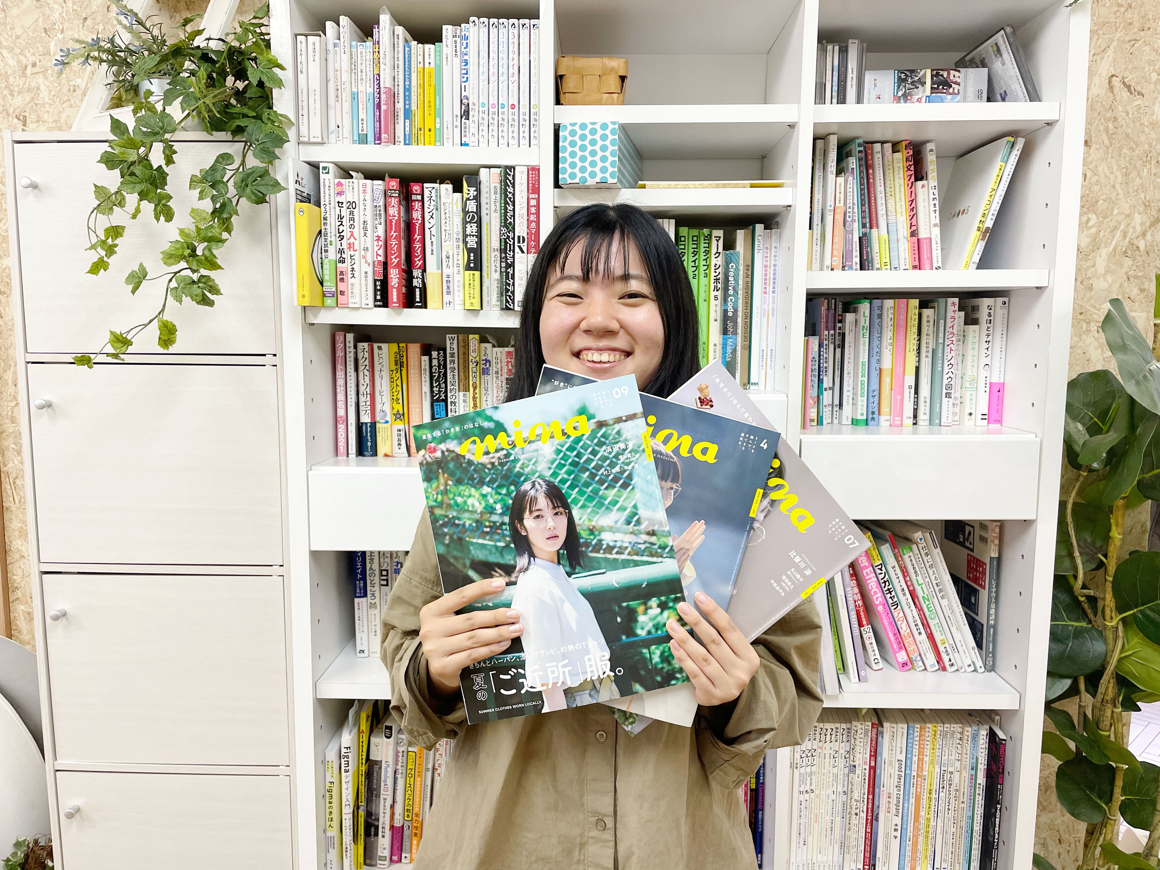 minaの冊子を持つ女性スタッフ