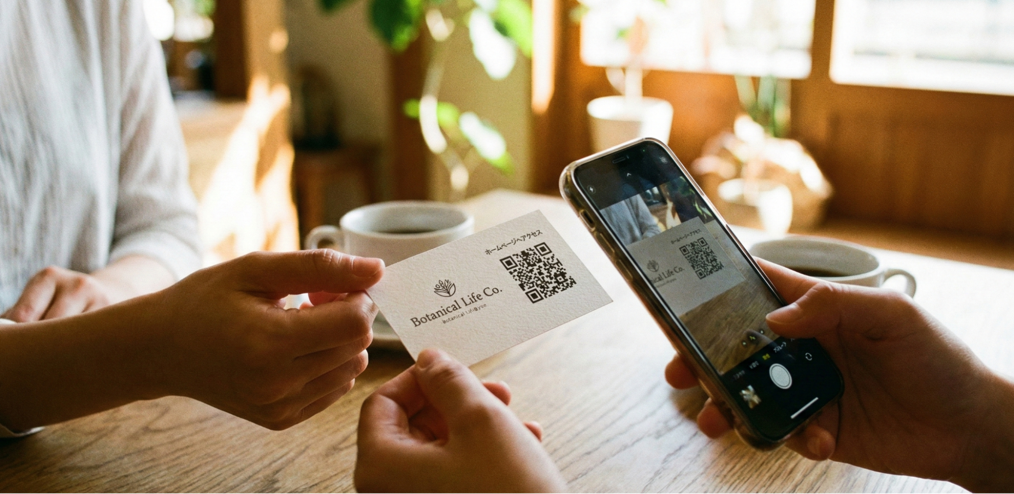 QRコード付きの名刺(ショップカード)を手渡しし、スマートフォンで読み取っている場面の写真。